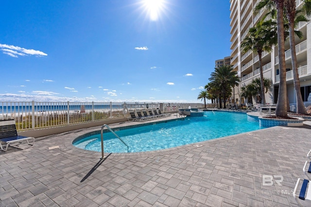 view of swimming pool featuring a water view and a patio area