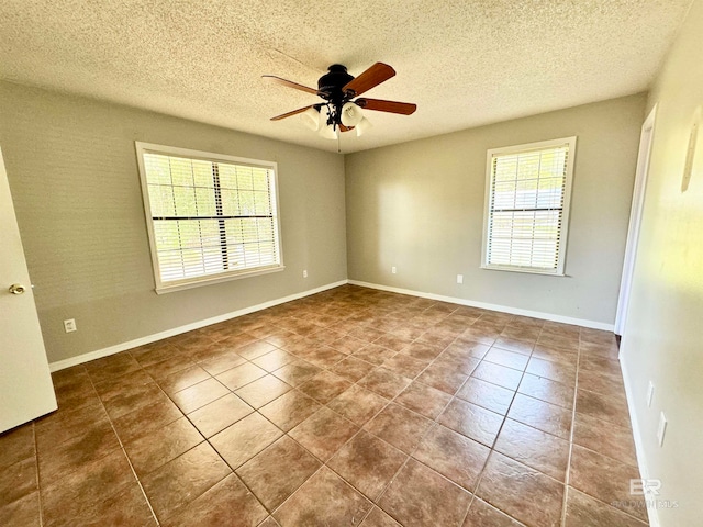 tiled spare room with ceiling fan and a textured ceiling