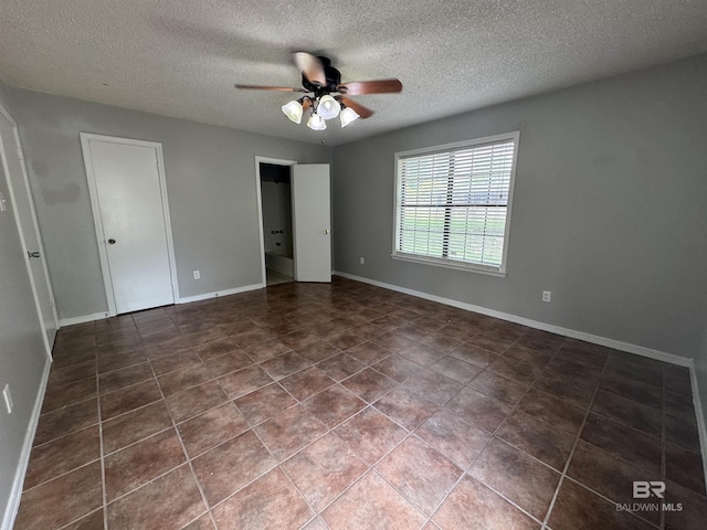 2316 Reneke Ave, Mobile, AL 36605 - unfurnished bedroom with a textured ceiling, dark tile patterned flooring, and a ceiling fan