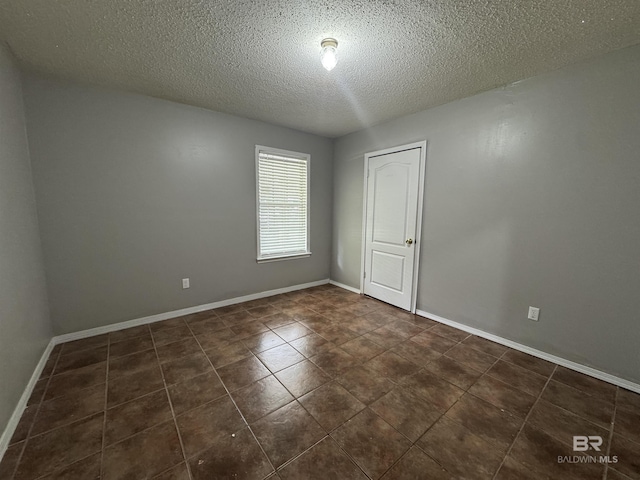 2316 Reneke Ave, Mobile, AL 36605 - spare room featuring a textured ceiling and dark tile patterned floors