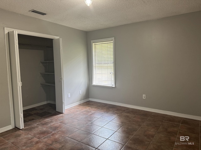 2316 Reneke Ave, Mobile, AL 36605 - unfurnished bedroom featuring a textured ceiling, a closet, and dark tile patterned floors