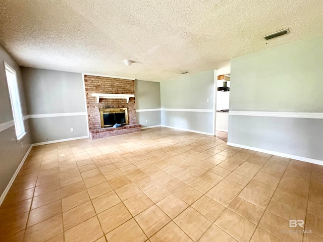 unfurnished living room with a fireplace, a textured ceiling, and light tile patterned flooring