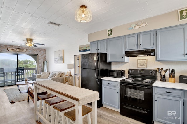 930 W Beach Blvd Unit 106, Gulf Shores, AL 36542 - kitchen with black appliances, under cabinet range hood, gray cabinetry, light wood finished floors, and a ceiling fan