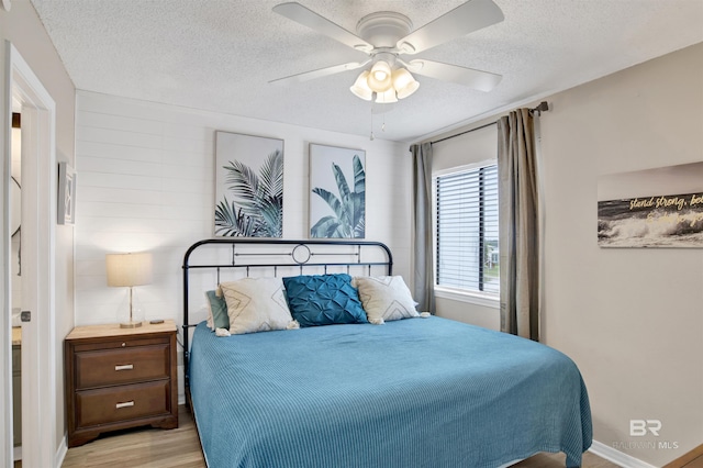 930 W Beach Blvd Unit 106, Gulf Shores, AL 36542 - bedroom with light wood-style flooring, a textured ceiling, and a ceiling fan