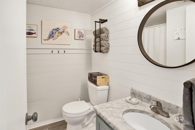 930 W Beach Blvd Unit 106, Gulf Shores, AL 36542 - bathroom with vanity, wood finished floors, toilet, and wood walls