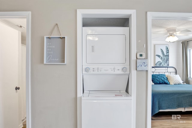 930 W Beach Blvd Unit 106, Gulf Shores, AL 36542 - washroom with estacked washer and dryer, a ceiling fan, and wood finished floors