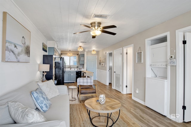 930 W Beach Blvd Unit 106, Gulf Shores, AL 36542 - living room with stacked washer / drying machine, ceiling fan, and light wood-style floors