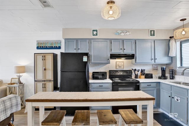930 W Beach Blvd Unit 106, Gulf Shores, AL 36542 - kitchen featuring a sink, range hood, light countertops, pendant lighting, and blue cabinetry