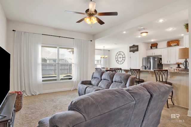 living room featuring visible vents, baseboards, light carpet, recessed lighting, and ceiling fan with notable chandelier