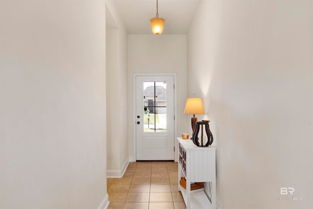 doorway to outside with light tile patterned floors and baseboards