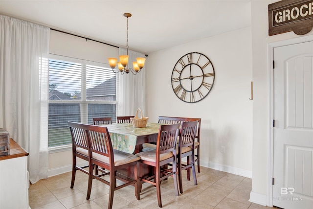 dining space with baseboards, a notable chandelier, and light tile patterned flooring