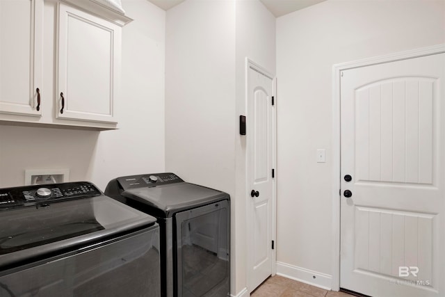 laundry room with cabinet space, light tile patterned floors, washer and dryer, and baseboards