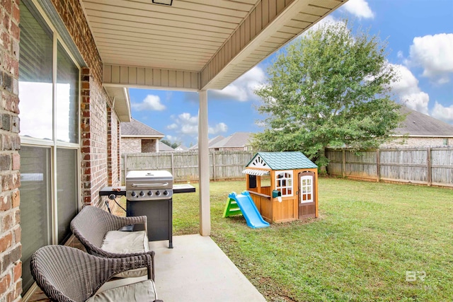 view of yard with a patio, a playground, and a fenced backyard