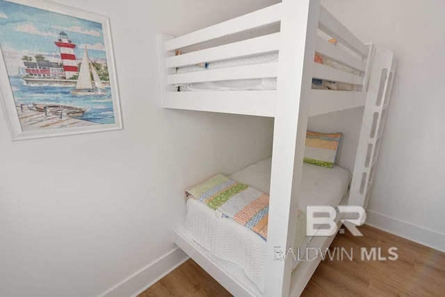 bedroom with baseboards and wood finished floors