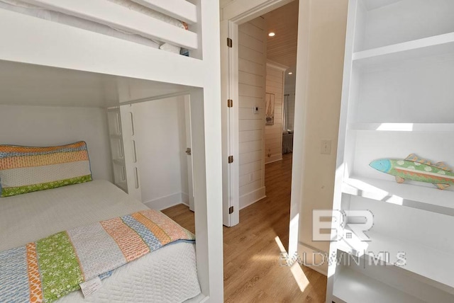 bedroom with wood finished floors, baseboards, and recessed lighting