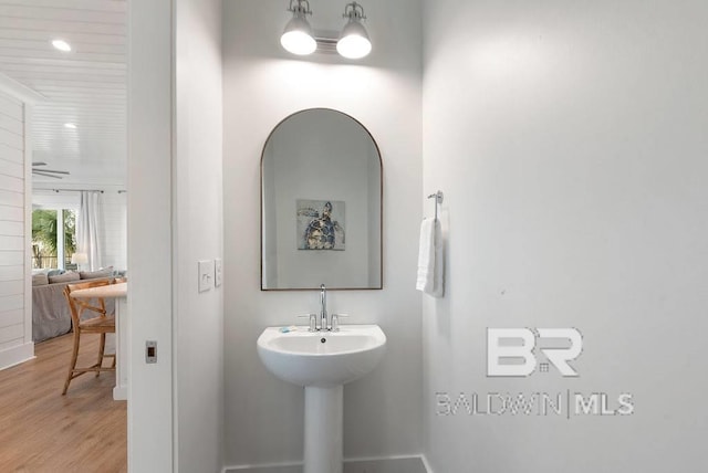 bathroom featuring baseboards, recessed lighting, and wood finished floors