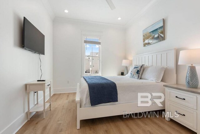 bedroom featuring light wood finished floors, baseboards, and ornamental molding