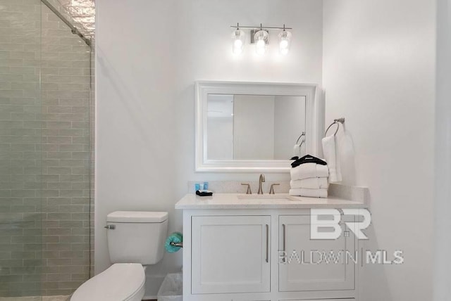 full bathroom with toilet, vanity, and a tile shower