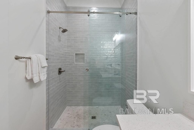 full bathroom featuring a shower stall, vanity, and toilet