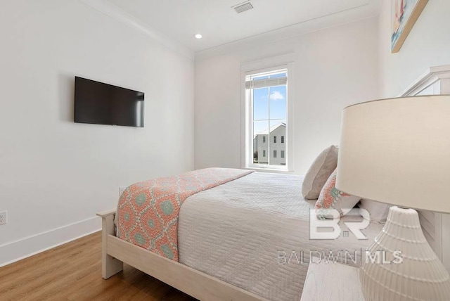 bedroom with recessed lighting, baseboards, visible vents, and wood finished floors