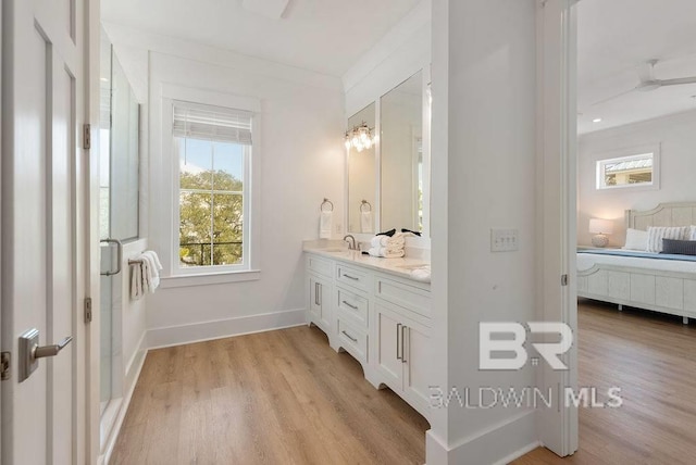 ensuite bathroom with ensuite bathroom, plenty of natural light, and wood finished floors