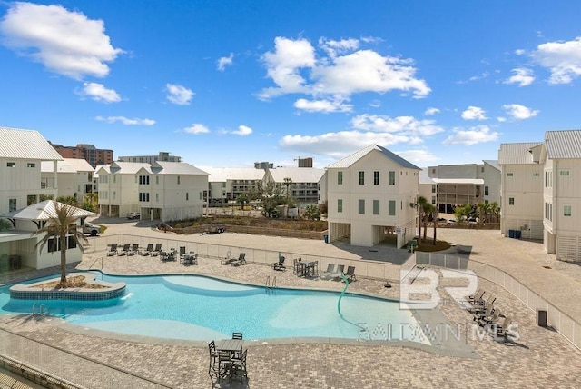 community pool featuring a patio, a residential view, and fence