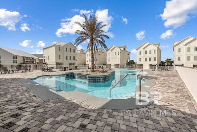 community pool with fence, a residential view, and a patio