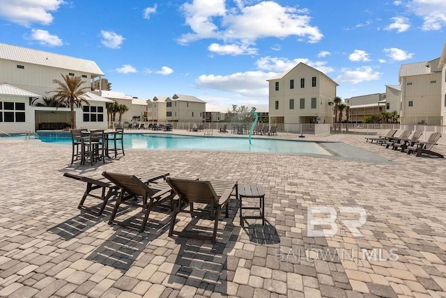 pool with a patio area and fence