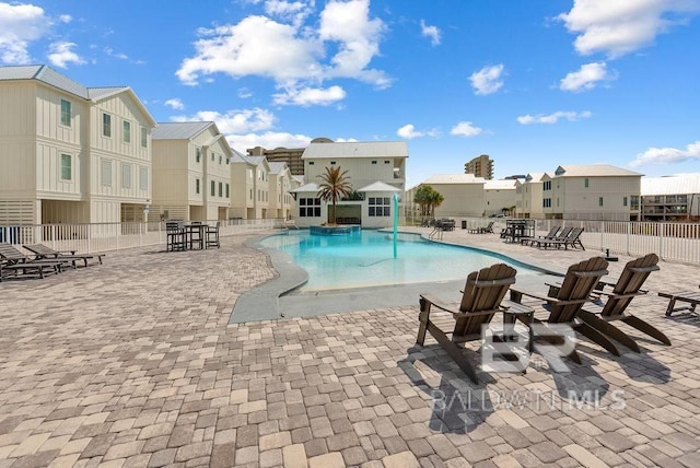 pool with a patio area, a residential view, and fence