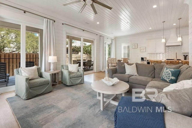 living area with wood ceiling, a wealth of natural light, ceiling fan, and light wood-style floors