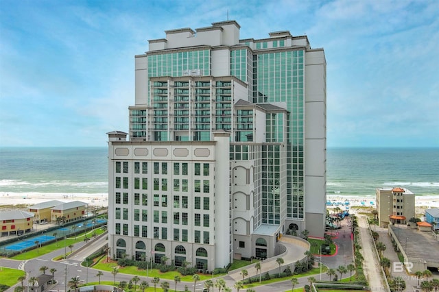 view of building exterior with a water view and a beach view