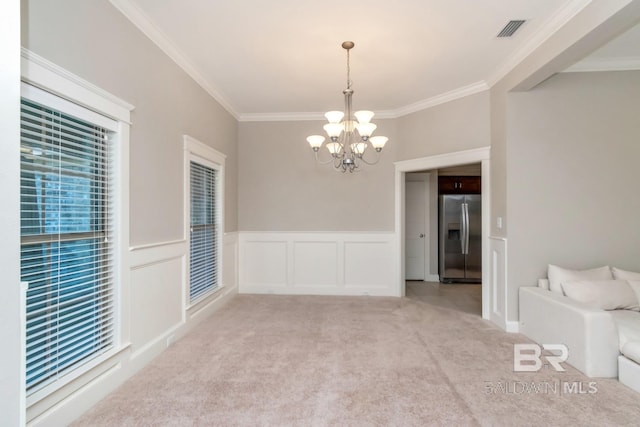 empty room with ornamental molding, light carpet, and an inviting chandelier