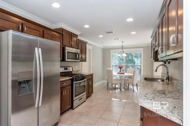 kitchen with sink, ornamental molding, appliances with stainless steel finishes, decorative light fixtures, and light tile patterned flooring