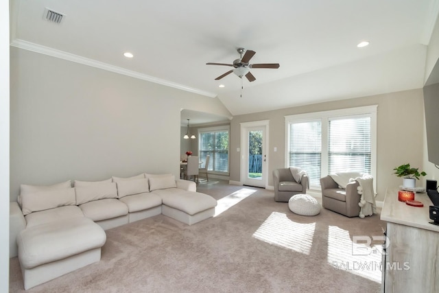 living room featuring ceiling fan with notable chandelier, crown molding, and light carpet