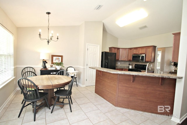 7920 Eagle Creek Dr, Daphne, AL 36526 - kitchen featuring black appliances, a chandelier, brown cabinets, a peninsula, and a breakfast bar