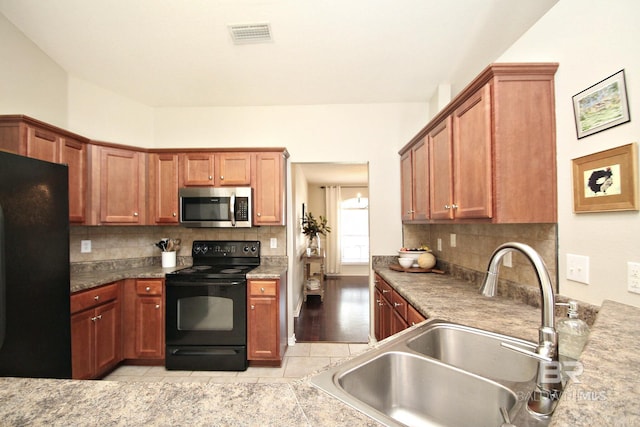 7920 Eagle Creek Dr, Daphne, AL 36526 - kitchen with black appliances, a sink, decorative backsplash, and brown cabinetry