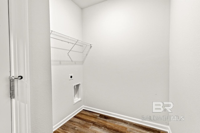 laundry area with laundry area, hookup for an electric dryer, dark wood finished floors, and baseboards