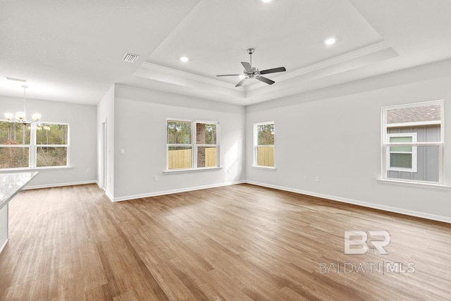 unfurnished living room with baseboards, a raised ceiling, and wood finished floors