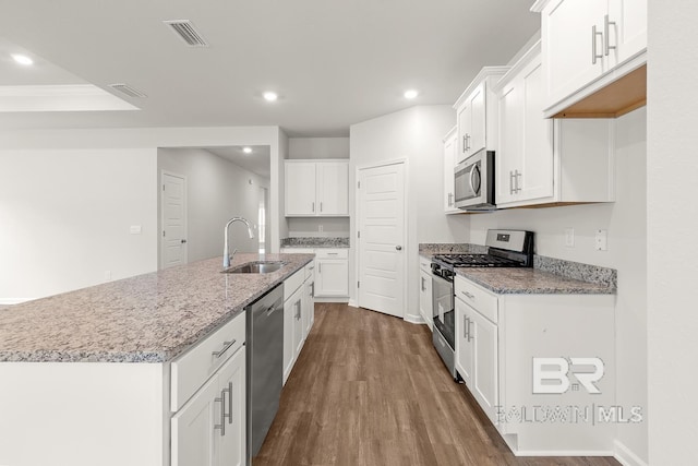 kitchen featuring a kitchen island with sink, a sink, visible vents, appliances with stainless steel finishes, and dark wood finished floors