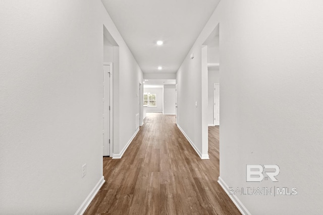 hall with dark wood-style floors and baseboards