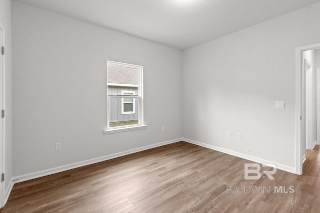 spare room with wood finished floors and baseboards