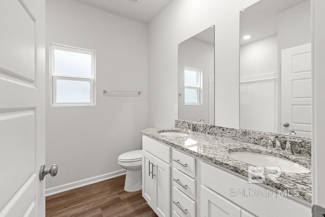 full bath featuring baseboards, a sink, toilet, and wood finished floors