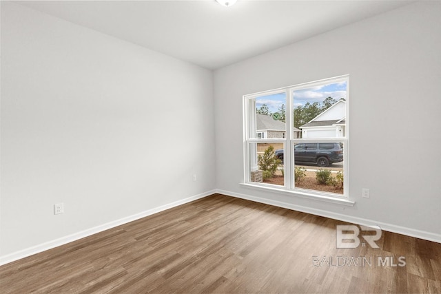 empty room with baseboards and wood finished floors