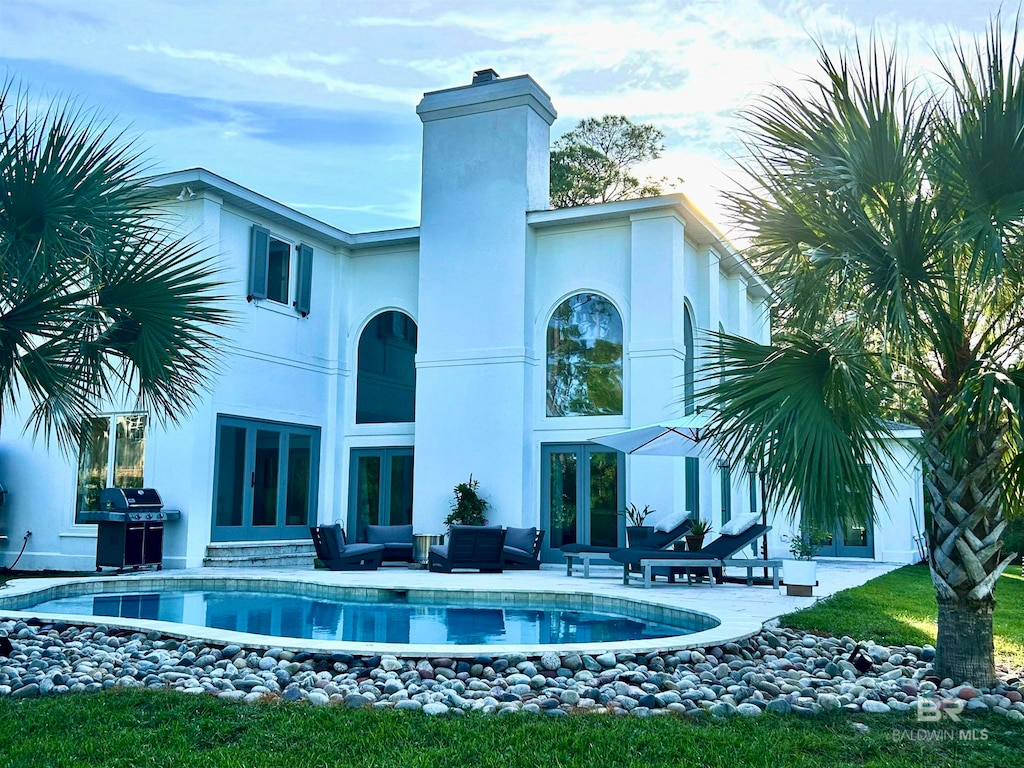 rear view of property featuring a patio, french doors, and an outdoor hangout area