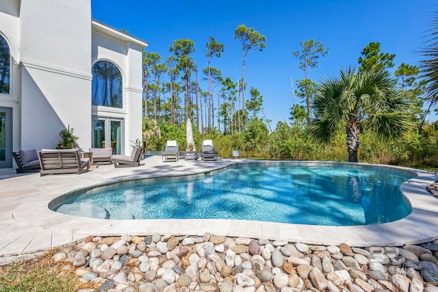 view of pool featuring an outdoor living space and a patio area