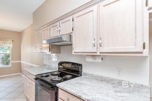 kitchen with under cabinet range hood, baseboards, light tile patterned floors, backsplash, and electric range