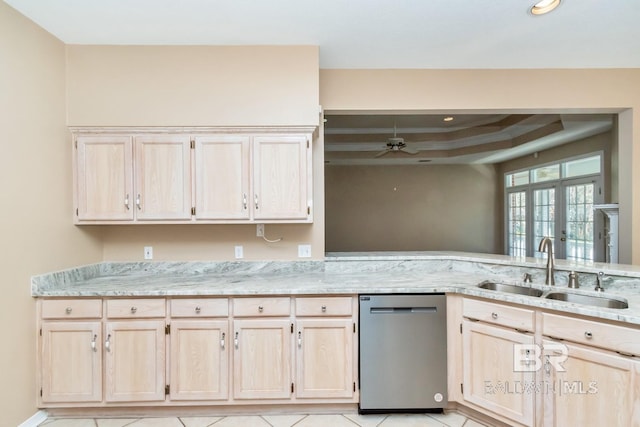 kitchen with a sink, dishwasher, ceiling fan, light brown cabinetry, and a raised ceiling