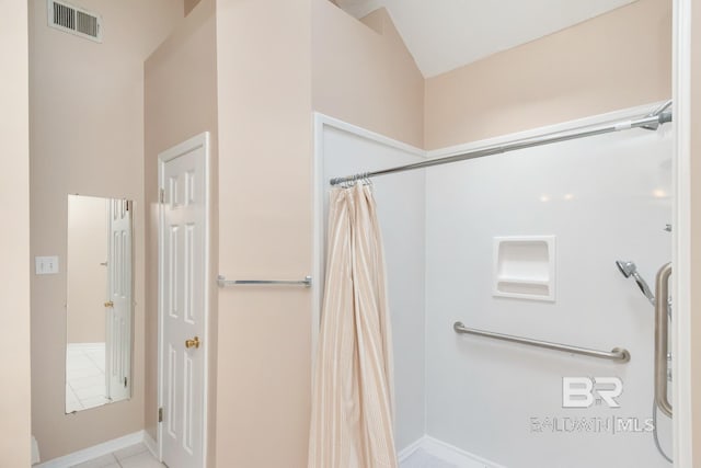 bathroom featuring tile patterned floors, curtained shower, visible vents, baseboards, and lofted ceiling