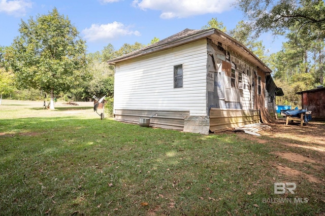 view of side of home with a yard