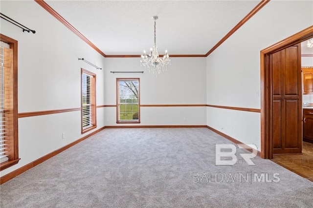 spare room with carpet, a notable chandelier, and ornamental molding